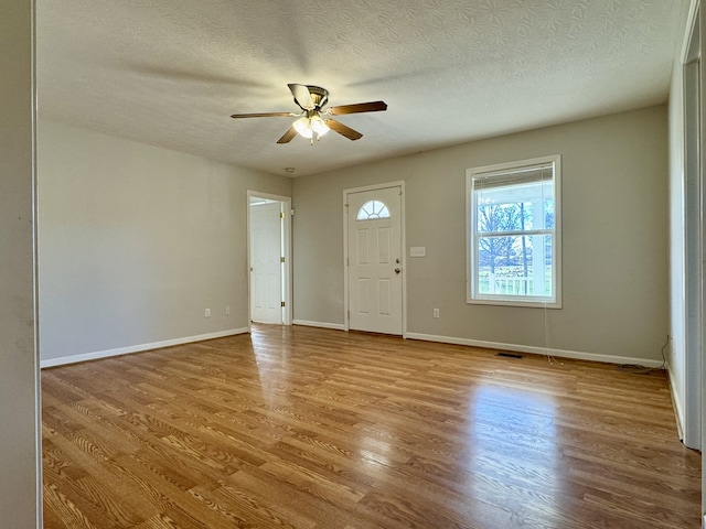 entrance foyer with ceiling fan, light wood-type flooring, and a textured ceiling