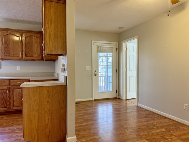 kitchen featuring ceiling fan, light hardwood / wood-style floors, and a textured ceiling