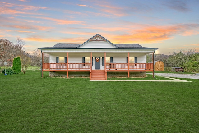 country-style home featuring a lawn, a storage shed, and covered porch