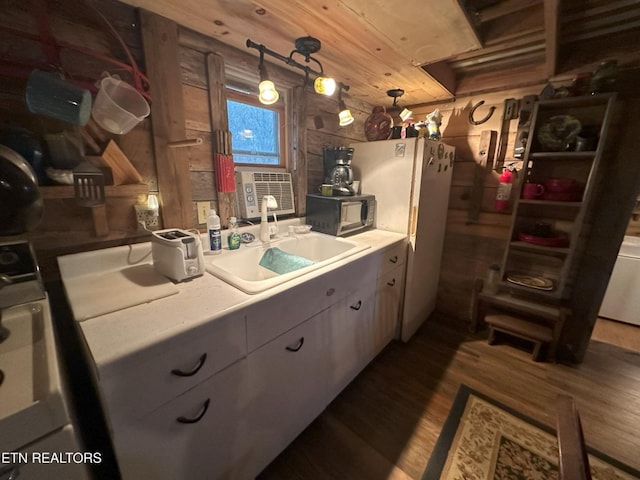 kitchen with cooling unit, wooden walls, sink, pendant lighting, and hardwood / wood-style flooring