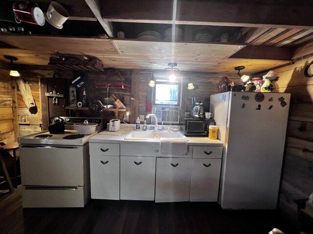 kitchen featuring white cabinetry, sink, white appliances, and wooden walls