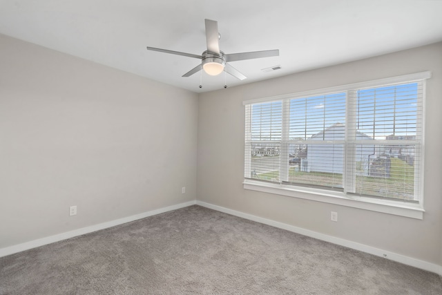 spare room with ceiling fan, light carpet, and a wealth of natural light