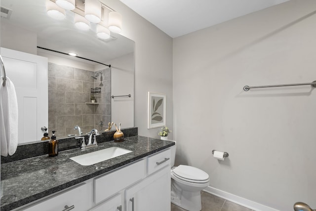 bathroom with tile patterned flooring, vanity, toilet, and tiled shower