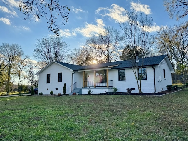 rear view of house featuring a porch and a yard