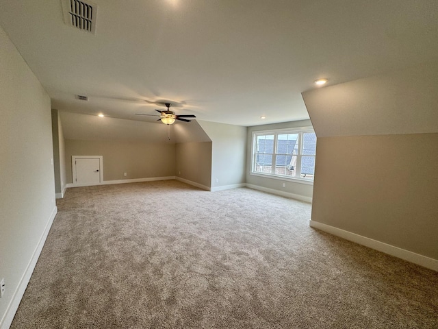 additional living space featuring baseboards, visible vents, ceiling fan, vaulted ceiling, and carpet floors