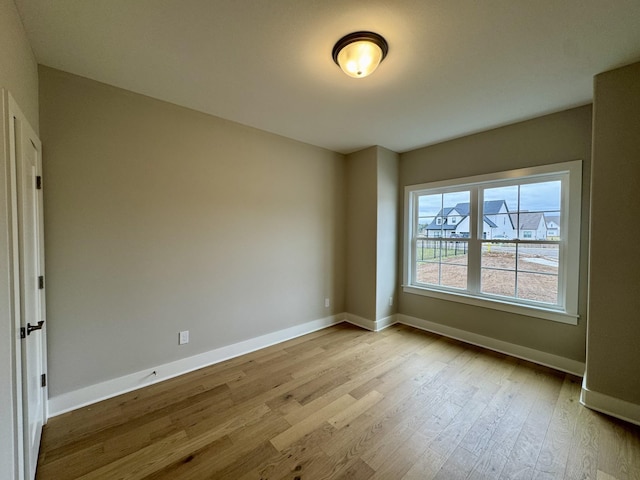 spare room with wood finished floors and baseboards