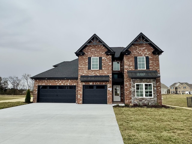 craftsman inspired home with a shingled roof, a front lawn, concrete driveway, a garage, and brick siding