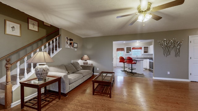 living room featuring hardwood / wood-style flooring, ceiling fan, and sink