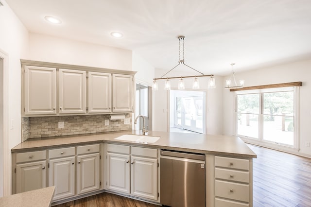 kitchen featuring dishwasher, sink, dark hardwood / wood-style floors, kitchen peninsula, and pendant lighting