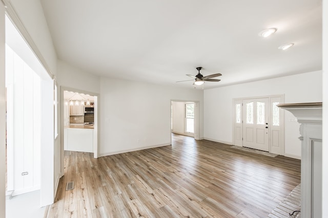 unfurnished living room featuring ceiling fan and light hardwood / wood-style floors