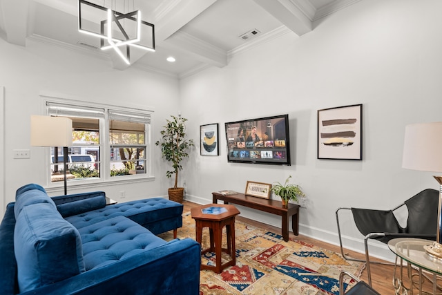 living room featuring a chandelier, wood-type flooring, ornamental molding, and beam ceiling