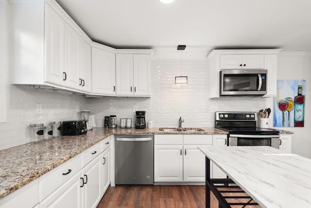 kitchen featuring stainless steel appliances, dark wood-type flooring, sink, pendant lighting, and white cabinetry