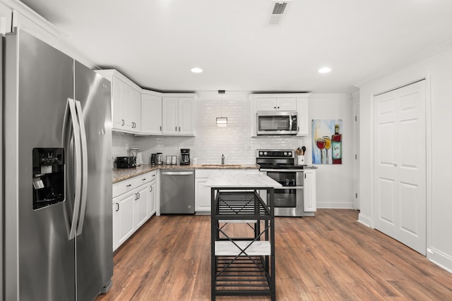 kitchen featuring light stone countertops, dark wood-type flooring, white cabinets, and stainless steel appliances