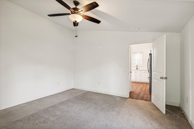 carpeted spare room with ceiling fan and lofted ceiling