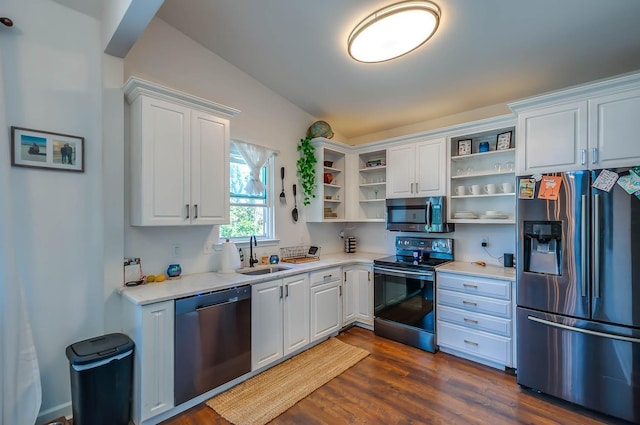 kitchen with sink, stainless steel appliances, dark hardwood / wood-style floors, vaulted ceiling, and white cabinets