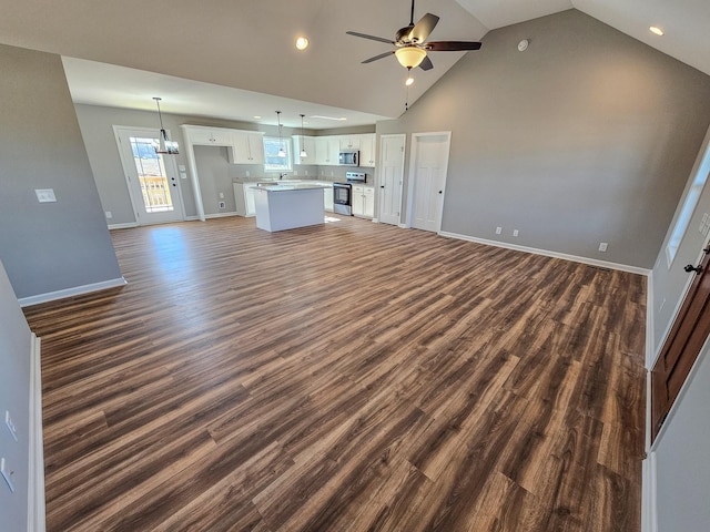 unfurnished living room with dark hardwood / wood-style flooring, high vaulted ceiling, sink, and ceiling fan