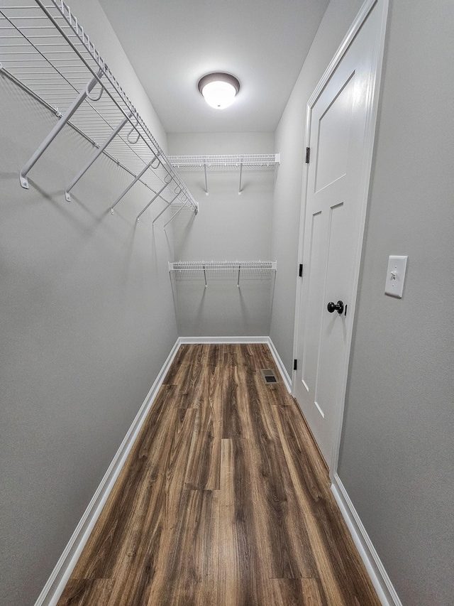 spacious closet with dark hardwood / wood-style floors