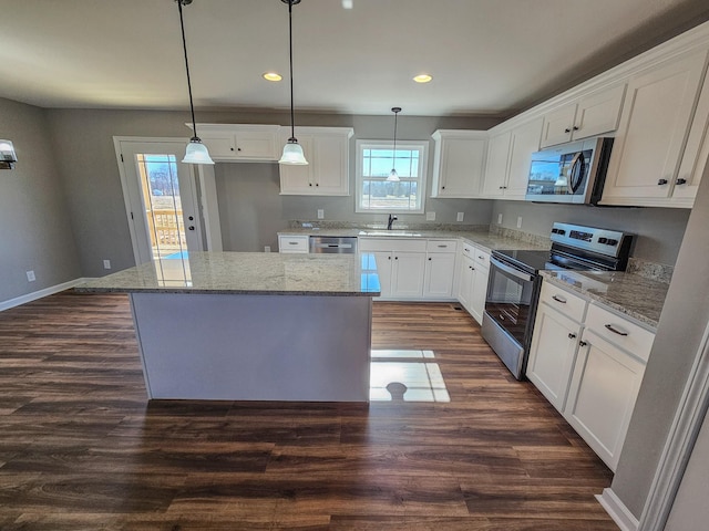 kitchen with hanging light fixtures, white cabinetry, appliances with stainless steel finishes, and a center island