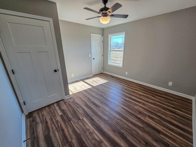 unfurnished bedroom with dark wood-type flooring and ceiling fan