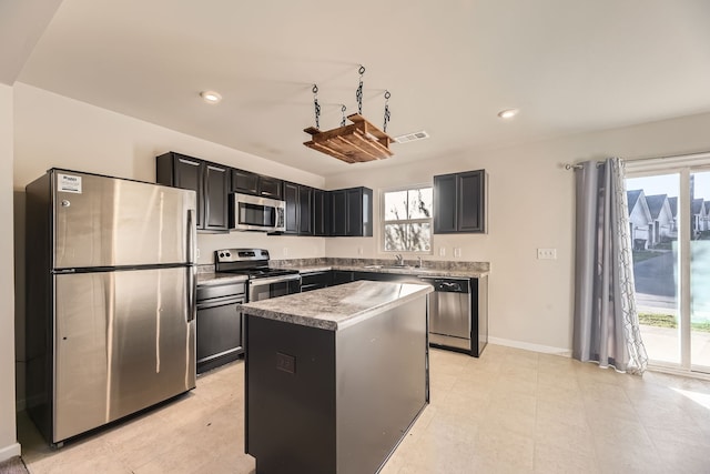 kitchen with plenty of natural light, a center island, sink, and stainless steel appliances