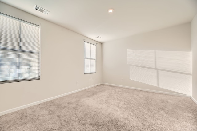 spare room with carpet floors and vaulted ceiling