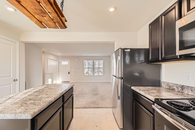 kitchen with light carpet, a center island, and appliances with stainless steel finishes