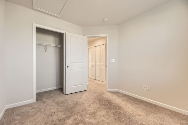 unfurnished bedroom featuring light carpet and a closet