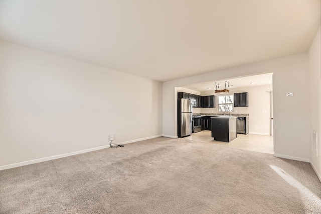 unfurnished living room with light carpet and sink