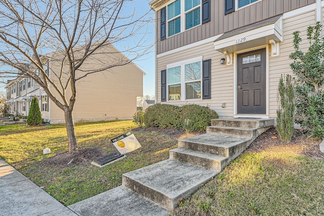 view of exterior entry with a lawn