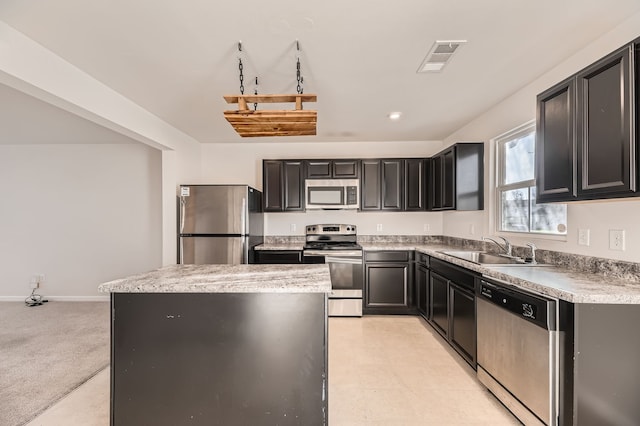 kitchen featuring a center island, light colored carpet, sink, appliances with stainless steel finishes, and light stone counters