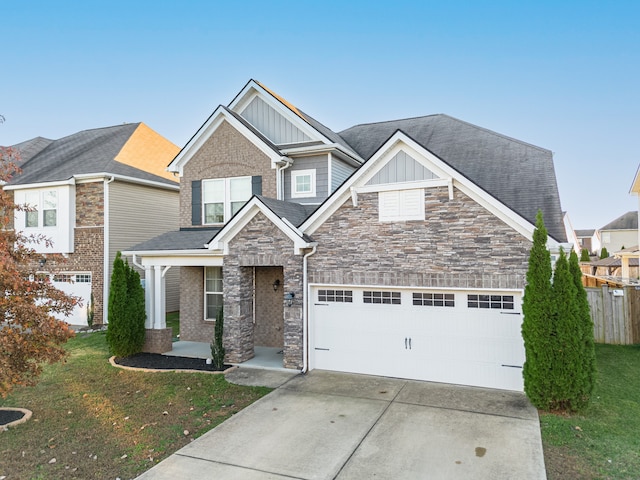 craftsman-style home featuring a front yard and a garage