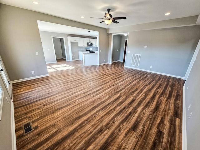 unfurnished living room with dark hardwood / wood-style floors and ceiling fan