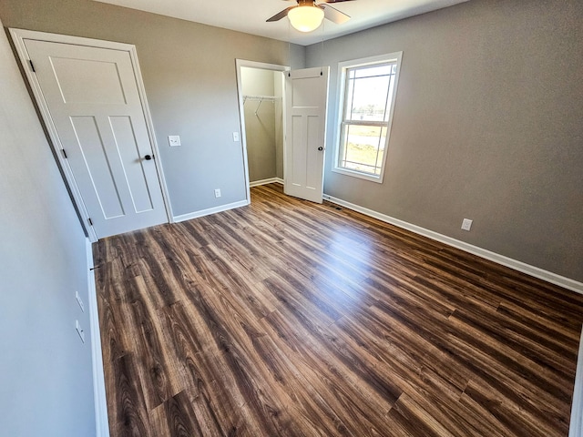 unfurnished bedroom with ceiling fan, dark hardwood / wood-style flooring, and a closet