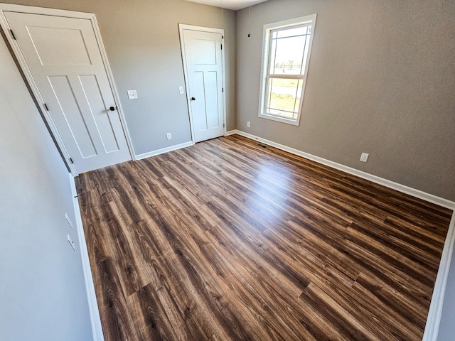 unfurnished bedroom featuring dark hardwood / wood-style floors