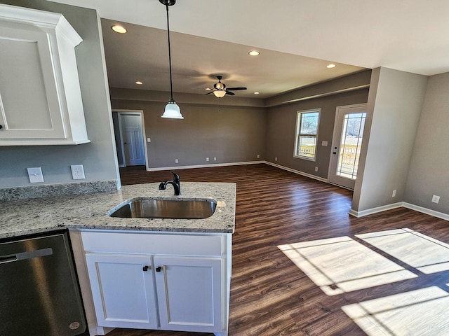 kitchen featuring white cabinetry, stainless steel dishwasher, sink, and light stone counters