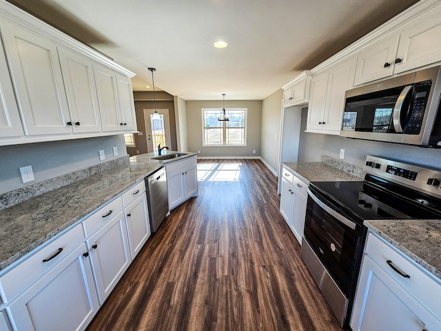 kitchen featuring appliances with stainless steel finishes, decorative light fixtures, sink, white cabinets, and dark hardwood / wood-style flooring