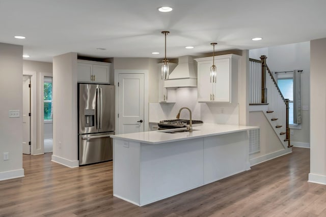 1410 Riverside Dr Unit A, Nashville, TN 37206 - kitchen with stainless steel refrigerator with ice dispenser, custom exhaust hood, light countertops, a peninsula, and wood finished floors