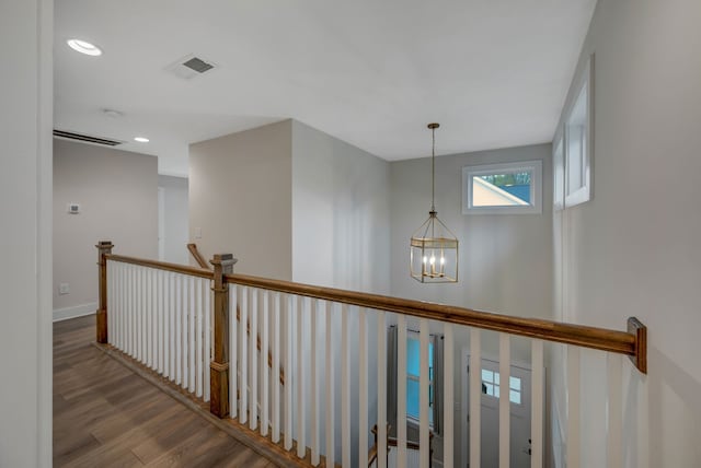 corridor featuring visible vents, wood finished floors, an inviting chandelier, an upstairs landing, and recessed lighting