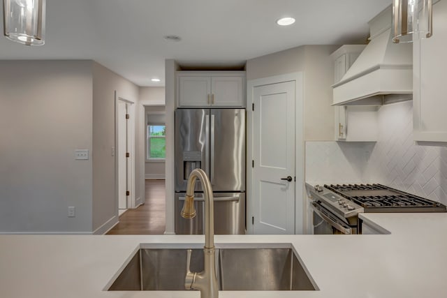 kitchen featuring recessed lighting, stainless steel appliances, light countertops, custom exhaust hood, and decorative backsplash