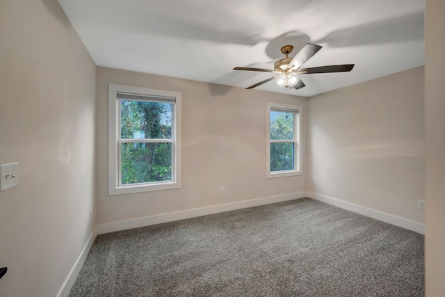 carpeted empty room with ceiling fan and baseboards