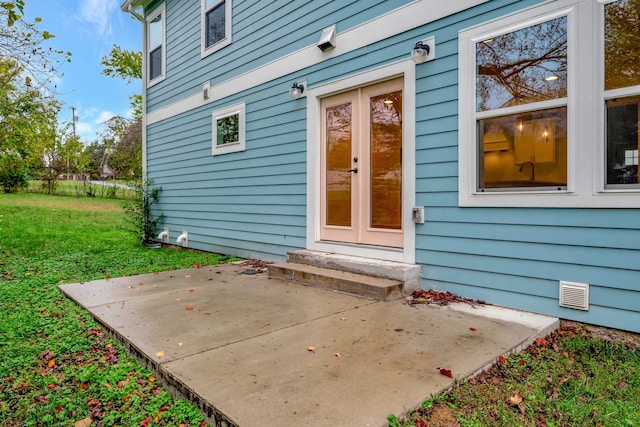 doorway to property featuring a lawn and a patio