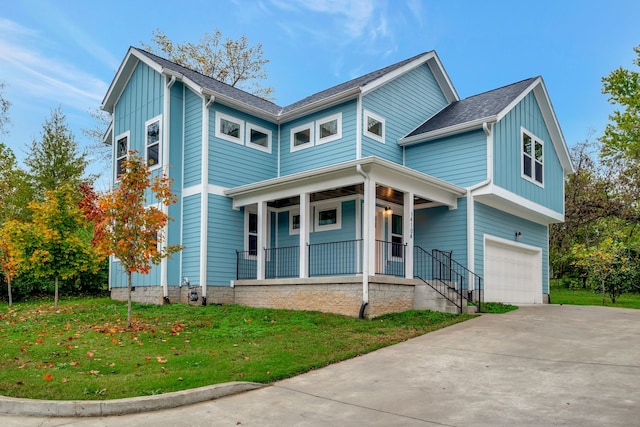 view of front of property featuring a garage, concrete driveway, a porch, board and batten siding, and a front yard