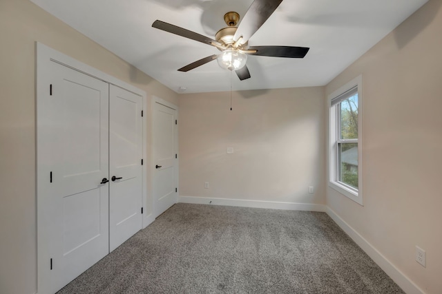 unfurnished bedroom featuring carpet floors, two closets, a ceiling fan, and baseboards