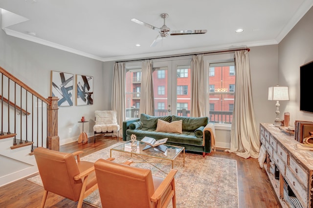 living room featuring hardwood / wood-style flooring, ceiling fan, crown molding, and french doors