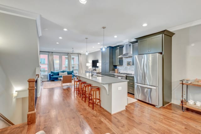 kitchen with appliances with stainless steel finishes, a kitchen island with sink, sink, hanging light fixtures, and a breakfast bar area