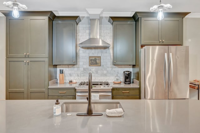 kitchen with decorative backsplash, appliances with stainless steel finishes, pendant lighting, and wall chimney range hood