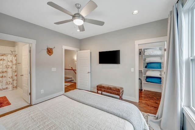 bedroom with ceiling fan, light wood-type flooring, and connected bathroom