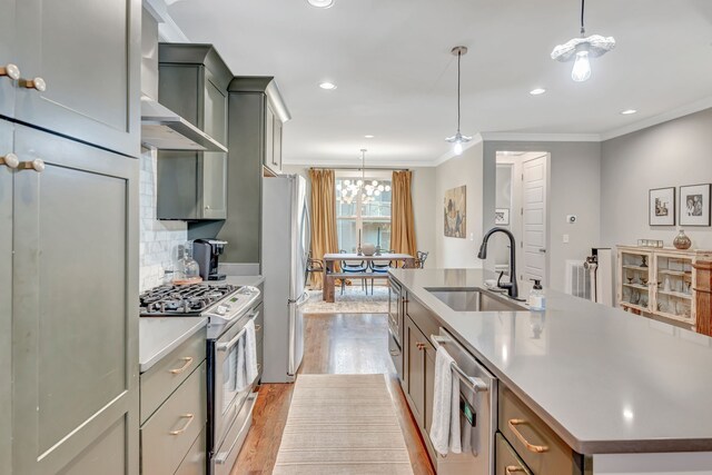 kitchen with crown molding, sink, a kitchen island with sink, and appliances with stainless steel finishes