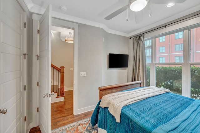 bedroom with ceiling fan, crown molding, and hardwood / wood-style flooring