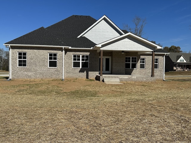 rear view of property featuring a lawn